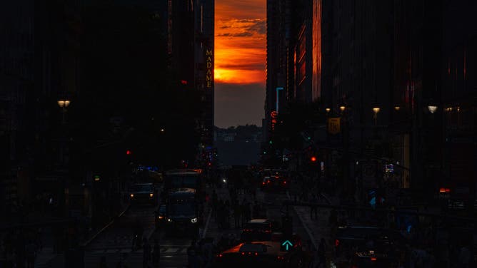 NEW YORK, NY - JULY 11: Crowds flock to 42nd Street in Manhattan to witness the second Manhattanhenge of the year on July 11, 2025. Manhattanhenge is a biannual event when the setting sun aligns precisely with the east-west grid of Manhattan's streets, creating a rare and picturesque urban sunset.