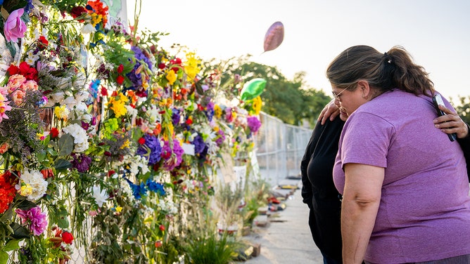 Community residents grieve and pay their respects at a memorial on July 10, 2025 in Kerrville, Texas.
