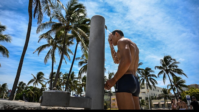A man takes a shower in the middle of a hot afternoon in Miami Beach, Florida, on July 22, 2025. Some 85 million Americans from South Dakota to Texas and North Carolina to Florida are under National Weather Service extreme heat warnings, watches or advisories, with temperatures reaching 100 degrees Fahrenheit (38 degrees Celsius). (Photo by CHANDAN KHANNA / AFP) (Photo by CHANDAN KHANNA/AFP via Getty Images)