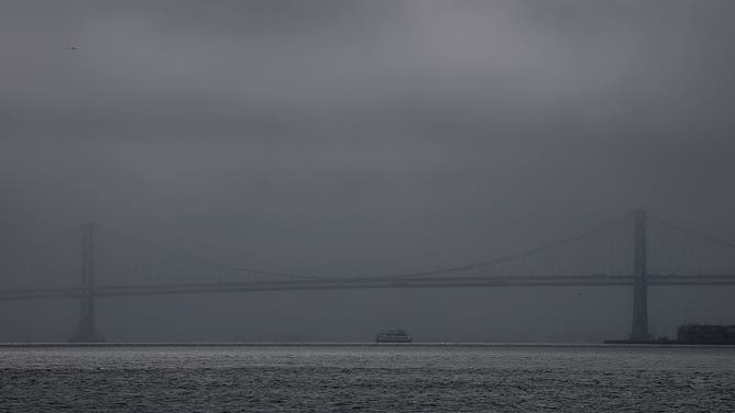 SAN FRANCISCO, CALIFORNIA - JULY 21: Fog rolls over the San Francisco-Oakland Bay Bridge on July 21, 2025 in San Francisco, California. As summer temperatures soar to record highs across much of the U.S., San Francisco is experiencing a very mild summer as a persistent marine layer hangs over the city on most days, keeping daily temperatures in the 50s and 60s. Since May, the city has only once reached a daytime high temperature of 70 degrees. 