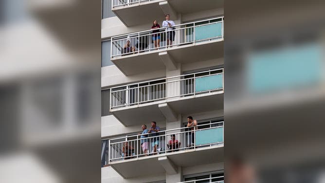 Visitors look on from their Waikiki hotel balcony waiting for the arrival of a tsunami at the Ala Wai Harbor, Waikiki, Oahu, Hawaii on July 29, 2025, after an 8.7 earthquake off of Russia's far east prompted tsunami alerts. A powerful 8.7 magnitude earthquake off Russia's far east has prompted tsunami alerts across parts of the Pacific including Japan, Hawaii, Russia and Ecuador, and warnings along the California coast, US authorities said late on July 29. The massive temblor triggered warnings of waves up to three metres (10 feet) possibly hitting the coasts of Russia, Hawaii and even Ecuador and Chile along South America's west coast, according to the US Pacific Tsunami Warning Center based in Honolulu, Hawaii. (Photo by Eugene Tanner / AFP) (Photo by EUGENE TANNER/AFP via Getty Images)