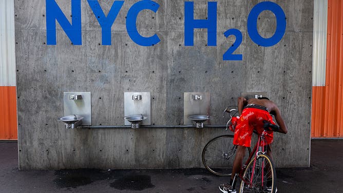 A teenager drinks water in the heat in a Brooklyn park as the region experiences another heatwave on July 29, 2025 in New York City.