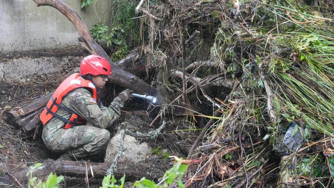 Texas National Guard service members assigned to Task Force Storm work in teams along the Guadalupe River bank conducting search and rescue operations and removing debris near Camp Mystic in Kerr County, Texas.