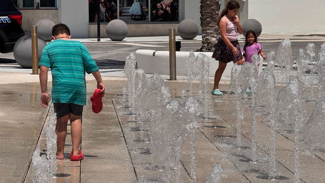 Children play in the water at a splash pad in West Palm Beach, Florida on July 29, 2025.