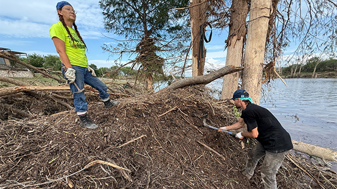 This image shows people searching through debris left behind after historic and deadly flooding in Texas.