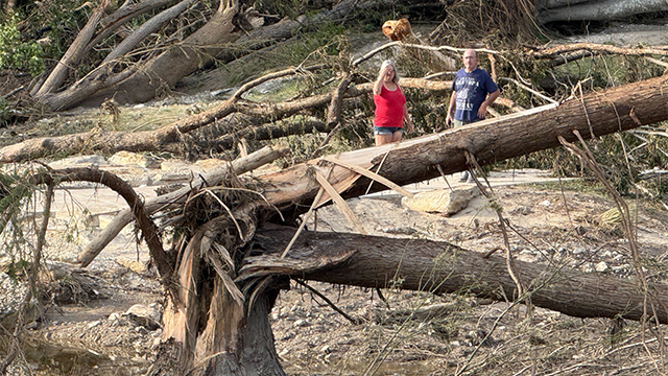 People are seen looking at damage left behind after historic and deadly flooding in Kerrville, Texas.