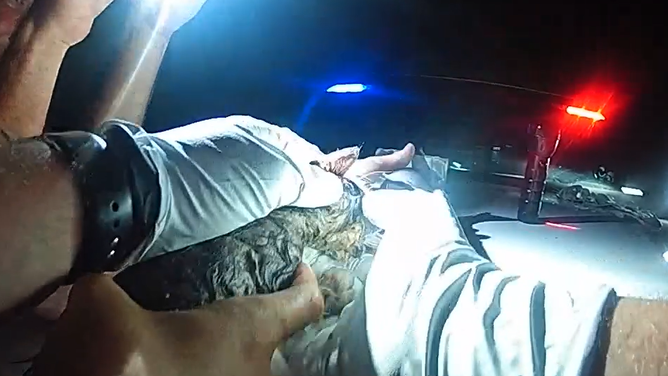The deputy works together with the woman to pull Piper out of the pipe.