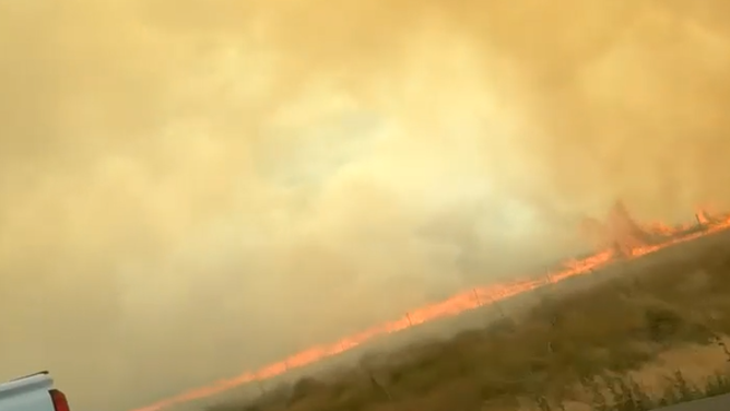 Smoke and flames fill the road.