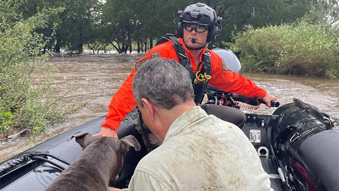 This photo shared by the Texas Game Wardens shows a first responder hel;ing evacuate a resident and their dog during flash flooding on July 13, 2025.