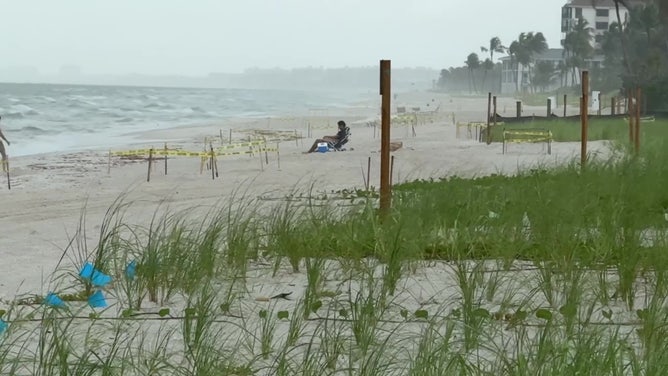 A brave beachgoer braves the rainfall  and storms successful  Naples, Florida connected  July 3, 2025.