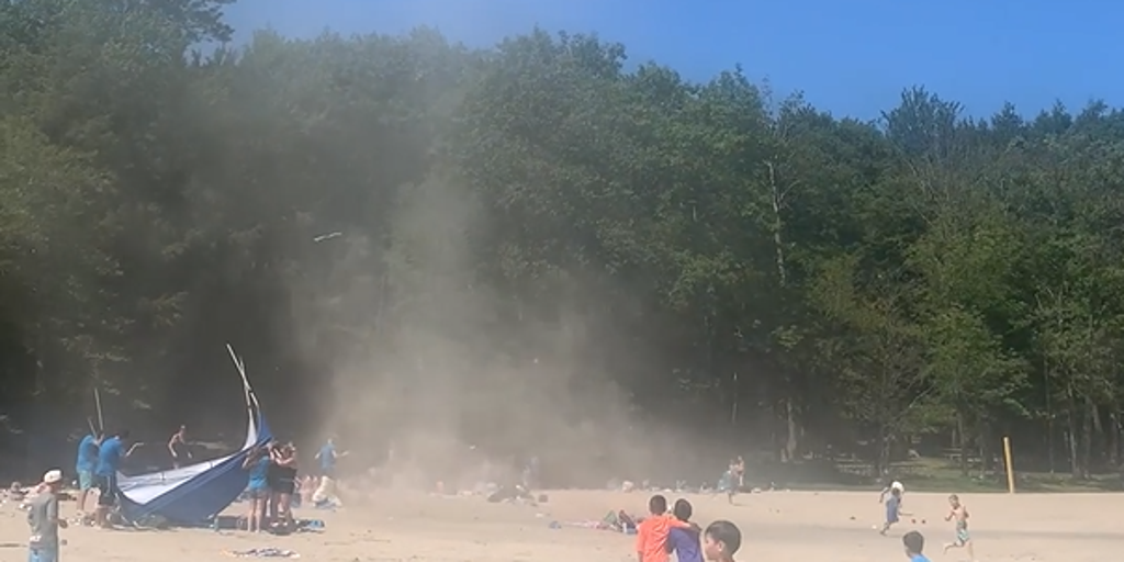 Dust devil wreaks havoc on New York beach as children run screaming for cover