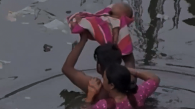 Watch: Man carries baby over head through chest-deep floodwater in India