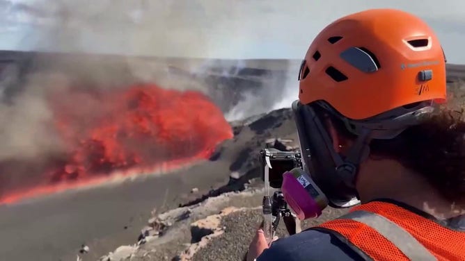 A idiosyncratic    is seen observing the latest eruptive occurrence  astatine  Hawaii's Kilauea volcano successful  August, 2025.