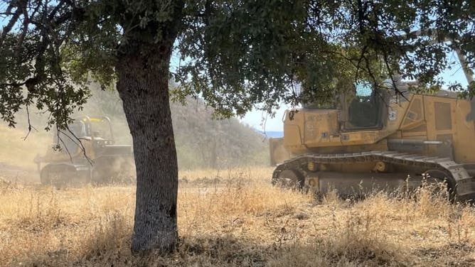 Bulldozers strengthen fire containment infrastructure in Fresno County.
