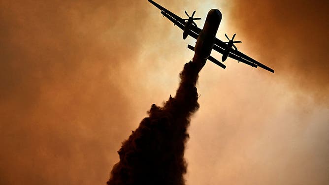 This photograph shows a canadair of the French civil security droping fire retardant over a wildfire near Fontjoncouse, southwestern France, on August 6, 2025.