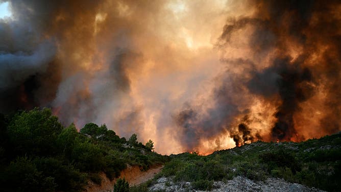A forest is engulfed in flames as a wildfire rages near Fontjoncouse, southwestern France, on August 6, 2025.