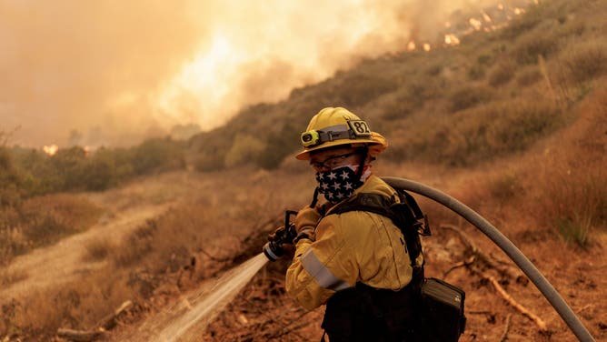 Firefighters battle flames from the Canyon Fire on August 7, 2025 in Castaic, California.