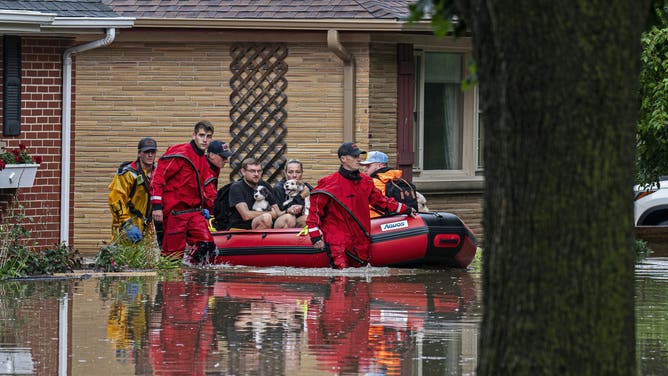 WAUWATOSA, WISCONSIN - AUGUST 10: (EDITOR'S NOTE: Alternate crop) First responders rescue people from flooding in their homes on August 10, 2025 in Wauwatosa, Wisconsin. Heavy downpours brought as much as 13 inches of rain to parts of southeast Wisconsin overnight, resulting in widespread flooding across the region. (Photo by Andy Manis/Getty Images)