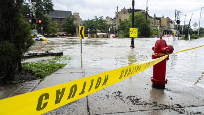 WAUWATOSA, WISCONSIN - AUGUST 10: Caution tape marks off a pedestrian pathway from flooding on August 10, 2025 in downtown Wauwatosa, Wisconsin. Heavy downpours brought as much as 13 inches of rain to parts of southeast Wisconsin overnight causing floods across the region. (Photo by Andy Manis/Getty Images)