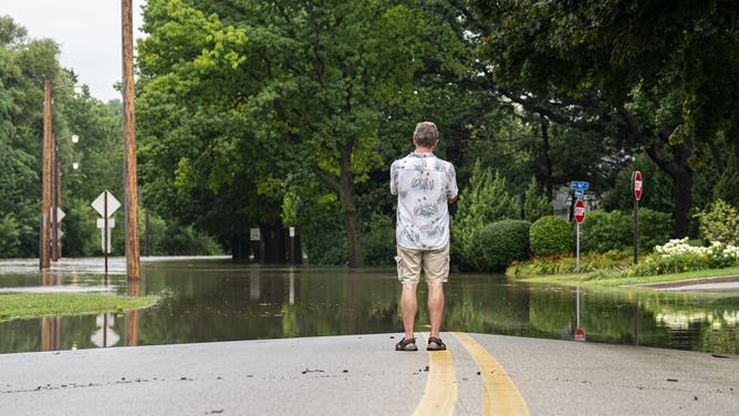 WAUWATOSA, WISCONSIN - AUGUST 10: A man looks at flooding on August 10, 2025 in Wauwatosa, Wisconsin. Heavy downpours brought as much as 13 inches of rain to parts of southeast Wisconsin overnight causing floods across the region. (Photo by Andy Manis/Getty Images)