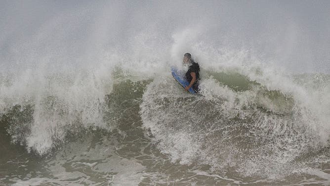 A surfer rides a wave at La Pared beach as Category 5 Hurricane Erin approaches in Luquillo, Puerto Rico on August 16, 2025. Hurricane Erin rapidly strengthened offshore to a "catastrophic" Category 5 storm on August 16, as rain lashed Caribbean islands and weather officials warned of possible flash floods and landslides.