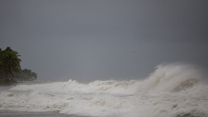 Heavy waves are seen at La Pared beach as Category 5 Hurricane Erin approaches in Luquillo, Puerto Rico on August 16, 2025. Hurricane Erin rapidly strengthened offshore to a "catastrophic" Category 5 storm on August 16, as rain lashed Caribbean islands and weather officials warned of possible flash floods and landslides. The first hurricane of what is expected to be a particularly intense Atlantic season, Erin is expected to drench Caribbean islands with rain and strong winds but not make landfall. (Photo by Ricardo ARDUENGO / AFP) (Photo by RICARDO ARDUENGO/AFP via Getty Images)