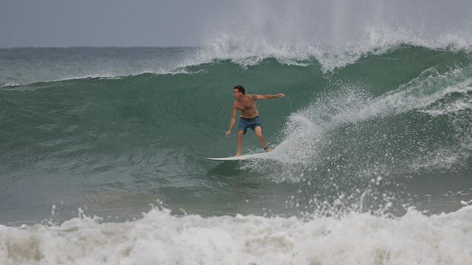 A surfer rides a wave at La Pared beach as Category 5 Hurricane Erin approaches in Luquillo, Puerto Rico on August 16, 2025. Hurricane Erin rapidly strengthened offshore to a "catastrophic" Category 5 storm on August 16, as rain lashed Caribbean islands and weather officials warned of possible flash floods and landslides. The first hurricane of what is expected to be a particularly intense Atlantic season, Erin is expected to drench Caribbean islands with rain and strong winds but not make landfall.