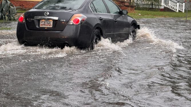 A car drives through flooding in Savannah, Georgia on Saturday, Aug. 2, 2025.