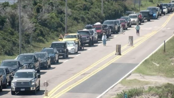 This image provided by the North Carolina Department of Transportation shows a line of vehicles waiting to evacuate Ocracoke Island ahead of life-threatening impacts from Hurricane Erin.