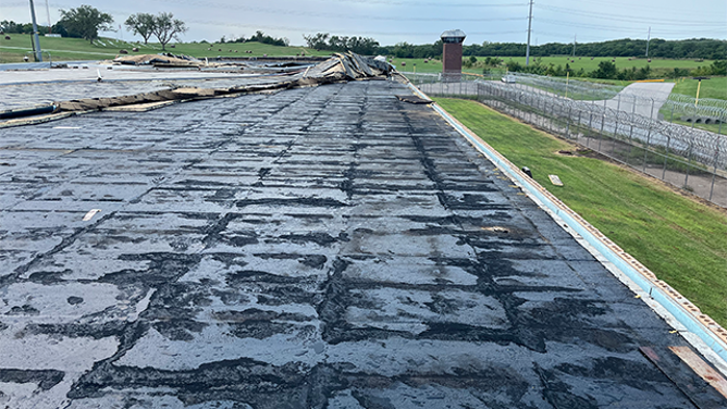 This image provided by the Nebraska Department of Correctional Services shows extensive damage to the Nebraska State Penitentiary after straight-line winds tore the roof off the facility.