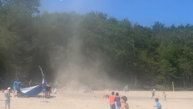 A dust devil picks up sand on the beach. 