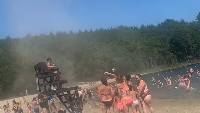 People run out of the lake away from the dust devil.