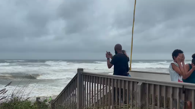 Winds whip sand into people's faces in Nags Head, North Carolina, during Erin's trek up the coast.