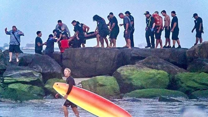 New York City firefighters rescue two swimmers from a rip current.