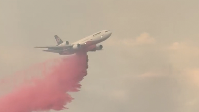 An airplane is seen dropping fire retardant on the 6-5 Wildfire in California on Sept. 2, 2025.