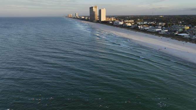 PANAMA CITY BEACH, FLORIDA - NOVEMBER 05: An aerial view of age group athletes competing in the swim course at IRONMAN Florida on November 05, 2022 in Panama City Beach, Florida.