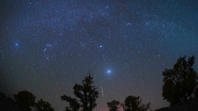 YULI, CHINA - OCTOBER 22: A meteor streaks across the sky over a desert during the Orionid meteor shower on October 22, 2023 in Yuli County,