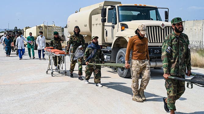 Afghan medical and Taliban security personnel carry stretchers for evacuated earthquake victims upon their arrival for medical assistance in Jalalabad on September 1, 2025. A massive rescue operation was underway in Afghanistan on September 1, after a strong earthquake and multiple aftershocks flattened homes in a remote, mountainous region, killing more than 800 people, the Taliban authorities said. (Photo by Wakil KOHSAR / AFP)