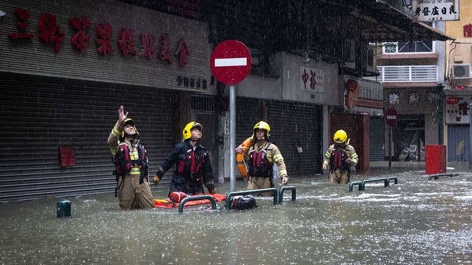 A rescue team talks with inhabitants of a building during the passing of Super Typhoon Ragasa in Macau on September 24, 2025. Fierce winds, pounding rain and high seas battered Hong Kong on September 24 as Super Typhoon Ragasa headed into southern China after causing a lake burst that killed at least 14 people in Taiwan.