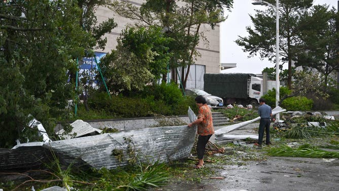 People clear debris after the passing of Typhoon Ragasa in Yangjiang, southern China's Guangdong province on September 24, 2025. Fierce winds, pounding rain and rough seas battered southern China on September 24 as powerful Typhoon Ragasa made landfall in Guangdong province after killing at least 17 in Taiwan. (Photo by ADEK BERRY / AFP) (Photo by ADEK BERRY/AFP via Getty Images)