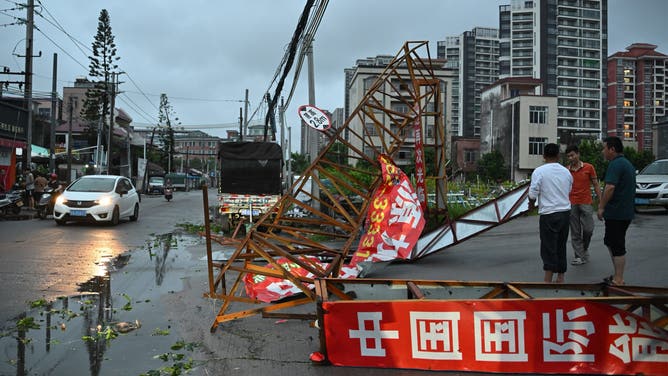 People remove a fallen iron gate after the passing of Typhoon Ragasa in Yangjiang, southern China's Guangdong province on September 24, 2025. Fierce winds, pounding rain and rough seas battered southern China on September 24 as powerful Typhoon Ragasa made landfall in Guangdong province after killing at least 17 in Taiwan. (Photo by ADEK BERRY / AFP) (Photo by ADEK BERRY/AFP via Getty Images)