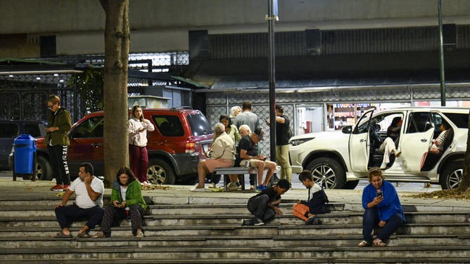 People sit at a public square after an earthquake was felt in Caracas, Venezuela, on September 25, 2025. A 6.3-magnitude quake shook northwestern Venezuela late Wednesday, following a slightly smaller tremor in the area, the US Geological Survey reported. The most recent earthquake was felt in the capital Caracas, more than 600 kilometres away. (Photo by Juan BARRETO / AFP) (Photo by JUAN BARRETO/AFP via Getty Images)