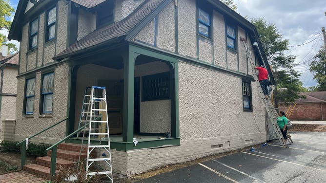 A worker does exterior work on a building in Historic Biltmore Village.