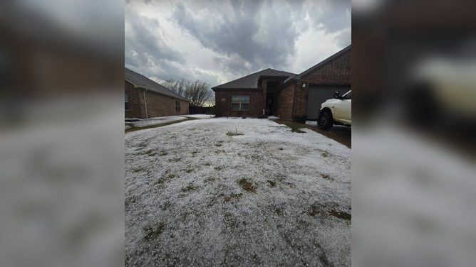 Hail piles up across backyard of home in Sanger, Texas Sunday afternoon.