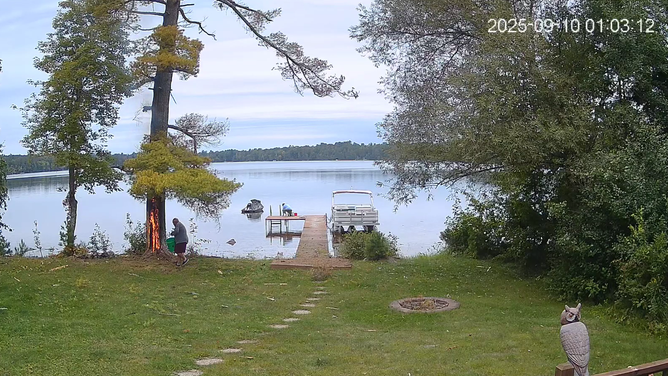 Neighbors splash lake water onto the burning tree trunk.