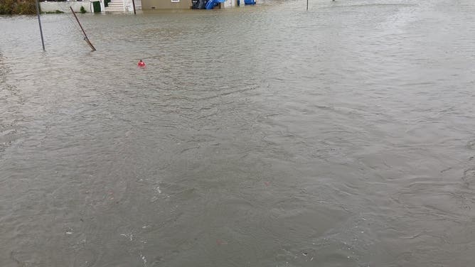 The red top of a fire hydrant can be seen peeking out of flood water in Beach Haven on Long Beach Island, New Jersey on Monday Oct. 13, 2025.