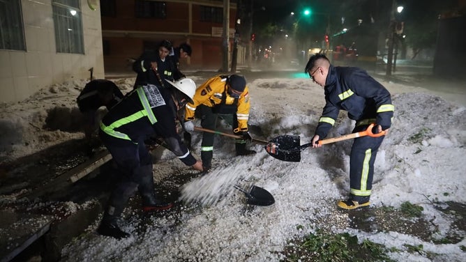 Workers scrape the ice up with shovels.