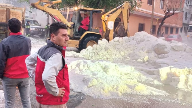 Tarija Mayor Johnny Torres Terzo watches crews scrape up the hail.