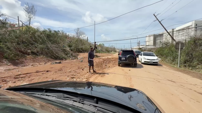 Man holds up downed powerline.