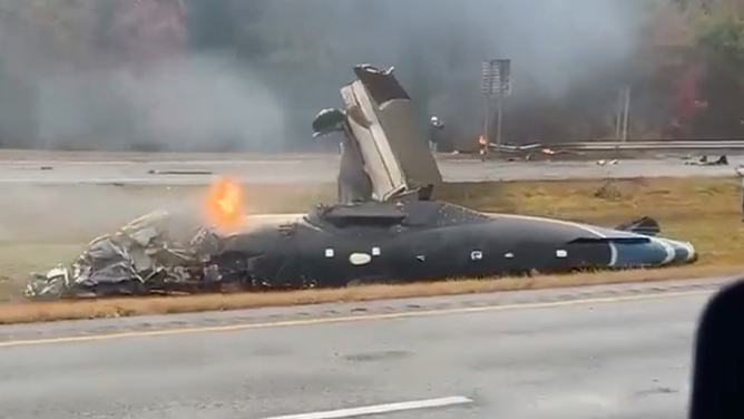 This image shows a plane on fire after it crashed onto a highway in Dartmouth, Massachusetts, during a nor'easter on Oct. 13, 2025.